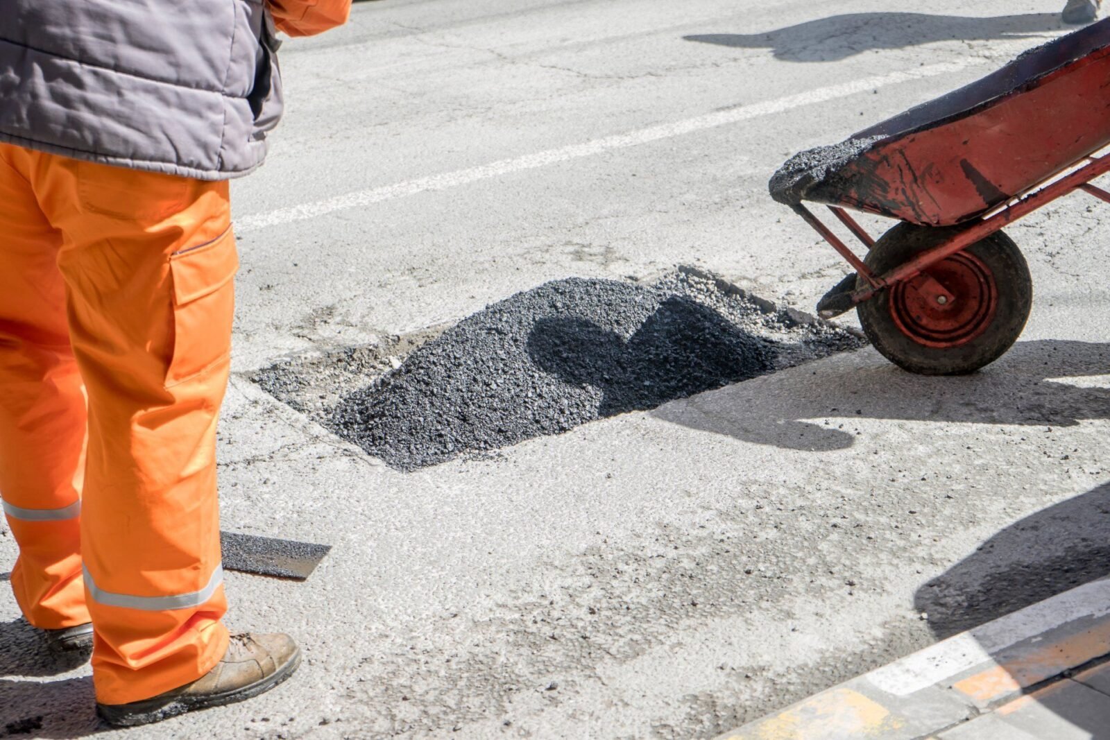 contractors from Palm Beach Asphalt patching a hole in a Boca Raton parking lot