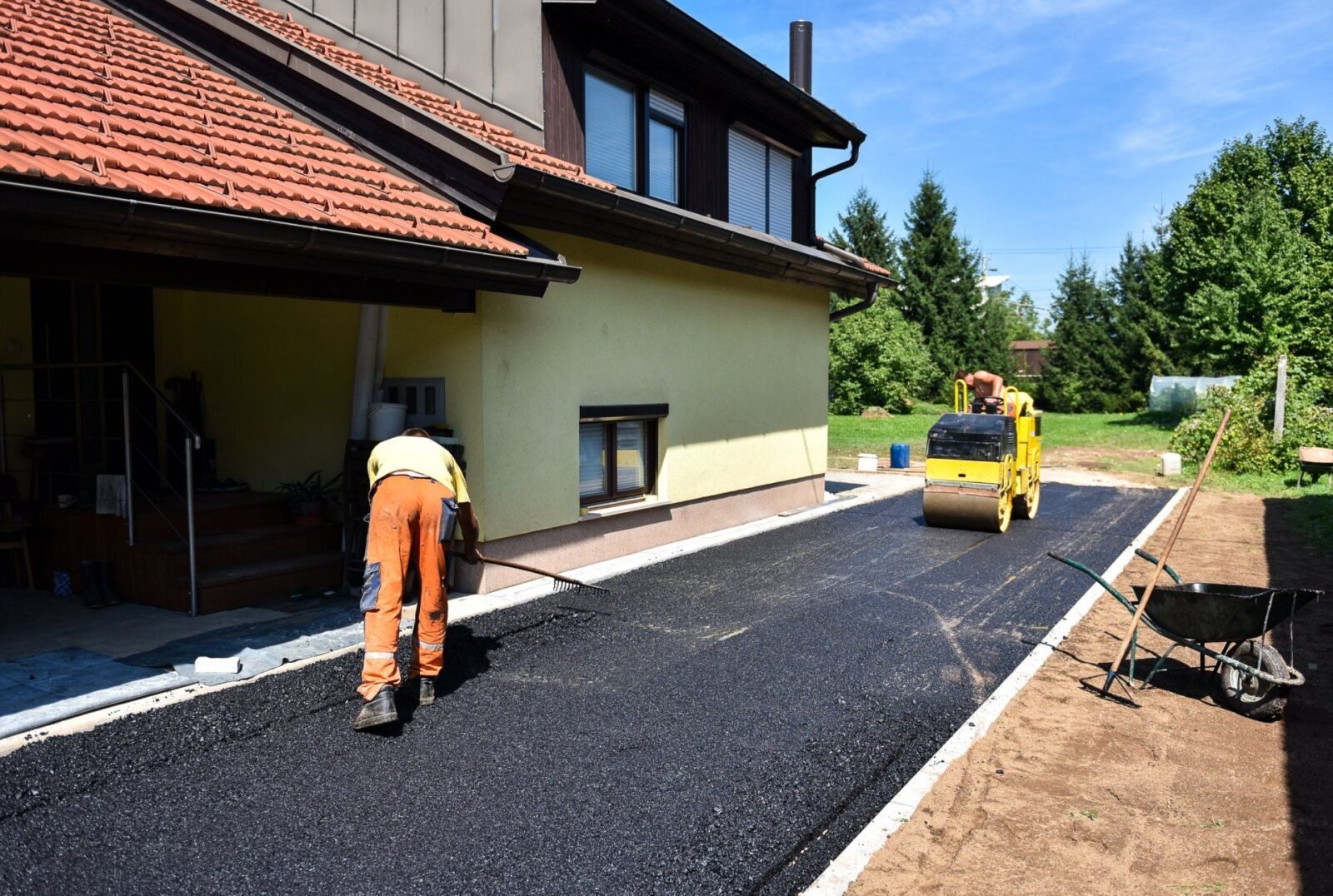 Asphalt contractors are sealcoating the pavement to improve the façade of the home.